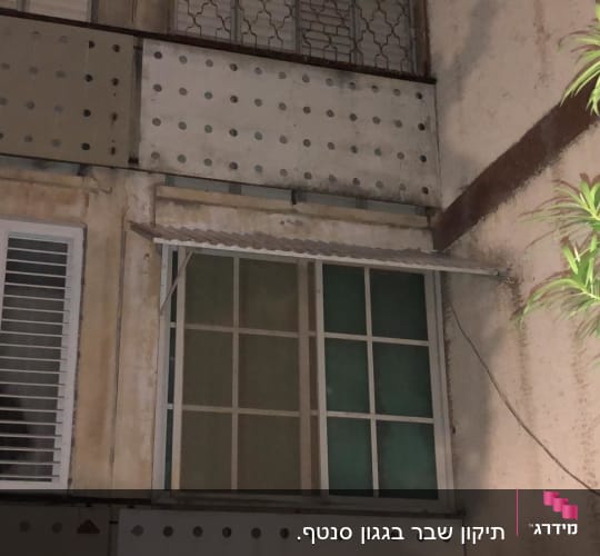 גגון מתכת מעל חלון עם תריסים